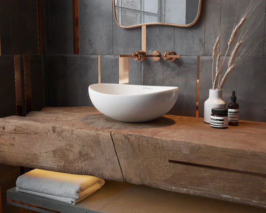 een witte waskom op een houten plank in de badkamer