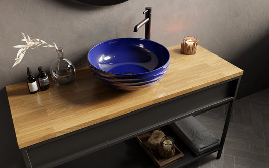blauwe waskom met zwarte kraan op houten badmeubel