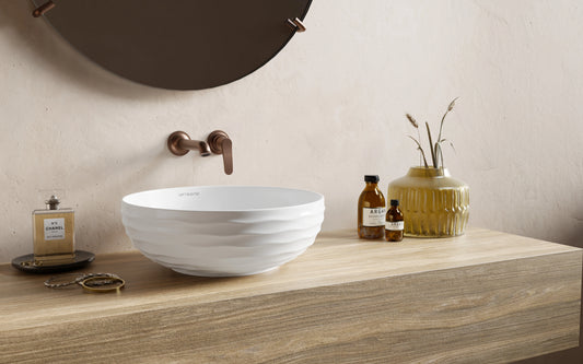 ronde keramische waskom met witte kleur op houten meubel
