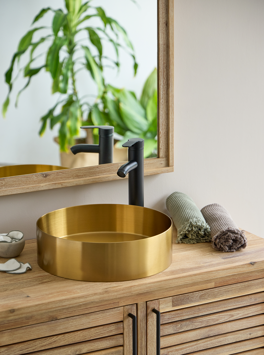 gouden waskom met zwarte kraan