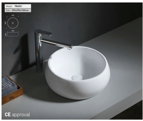 Ronde witte waskom met chromen kraan op grijs blad