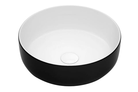 Ronde keramische waskom met zwarte buitenkant en witte binnenzijde, passend bij een eigentijdse badkamerstijl