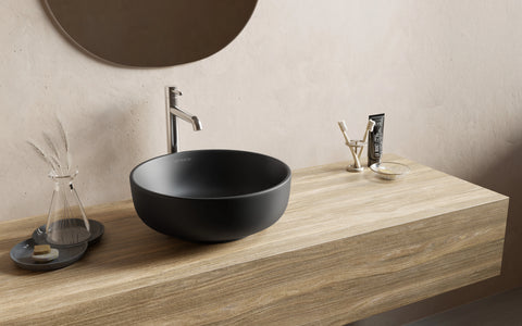 Ronde opzetwaskom van zwart keramiek met matte afwerking in moderne badkamer